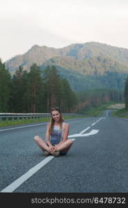 Woman sitting on the road. Woman sitting on the beauty road in mountain