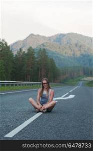 Woman sitting on the road. Woman sitting on the beauty road in mountain