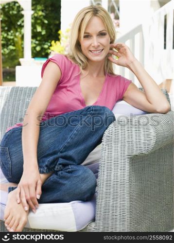 Woman sitting outdoors on patio smiling