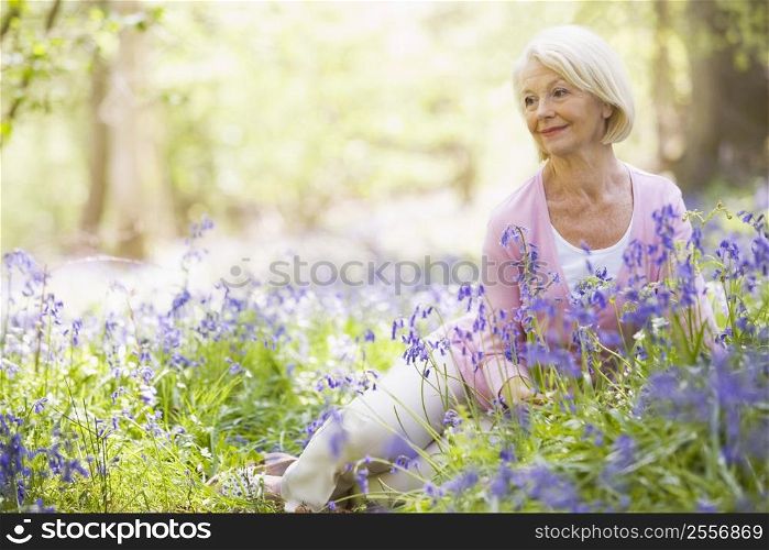 Woman sitting outdoors with flowers smiling