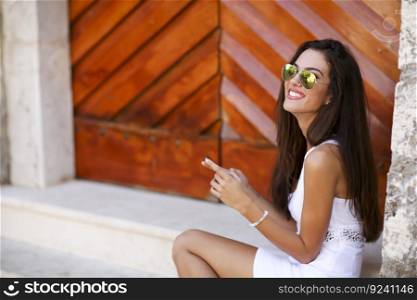 Woman sitting outside with a mobile phone