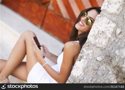 Woman sitting outside with a mobile phone