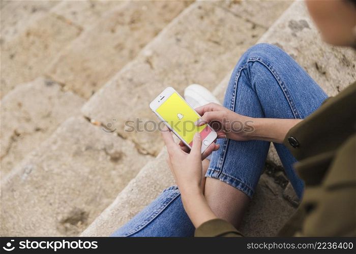 woman sitting staircase using snapchat app smartphone