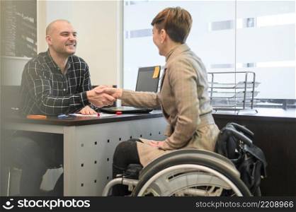 woman sitting wheelchair shaking hands