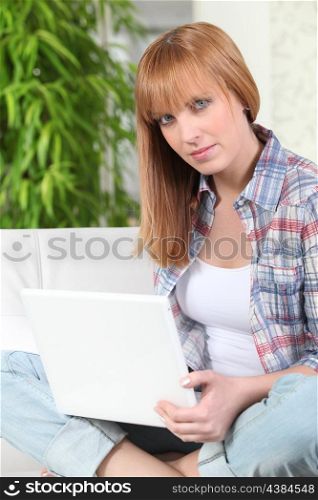 Woman sitting with laptop computer indoors