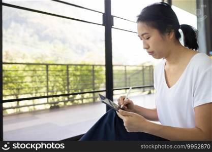 woman sitting with using tablet in a bed at home. The use of concept of new generation, family, parenthood, authenticity, connection, technology.