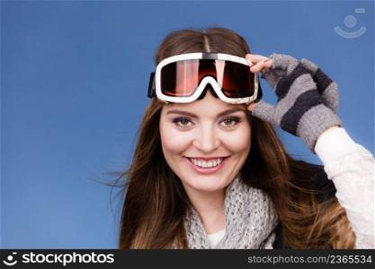 Woman skier girl wearing warm clothing ski googles portrait. Winter sport activity. Beautiful sportswoman on blue studio shot. skier girl wearing warm clothes ski googles portrait. 