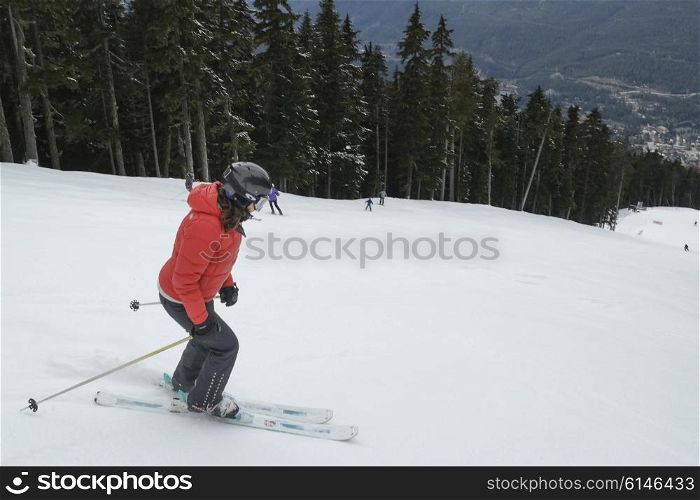 Woman skiing on snow covered ski slope, Whistler, British Columbia, Canada