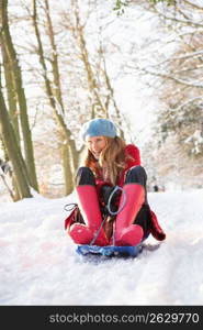 Woman Sledging Through Snowy Woodland