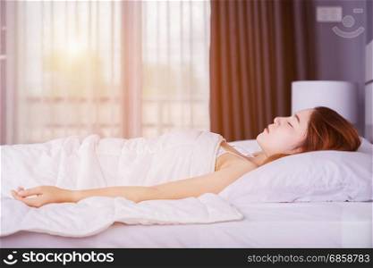 Woman sleeping on bed in bedroom with soft light