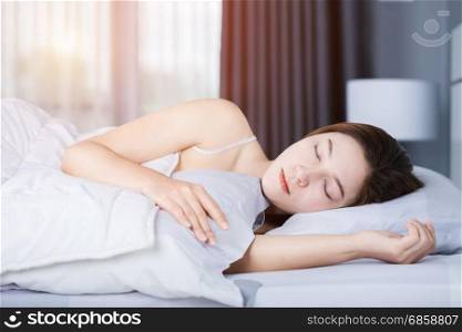 Woman sleeping on bed in the bedroom with soft light
