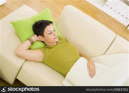 Woman sleeping on sofa at home.