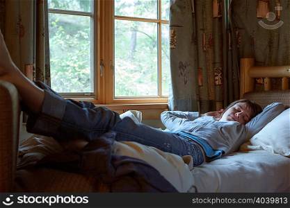 Woman sleeping with legs on bed frame