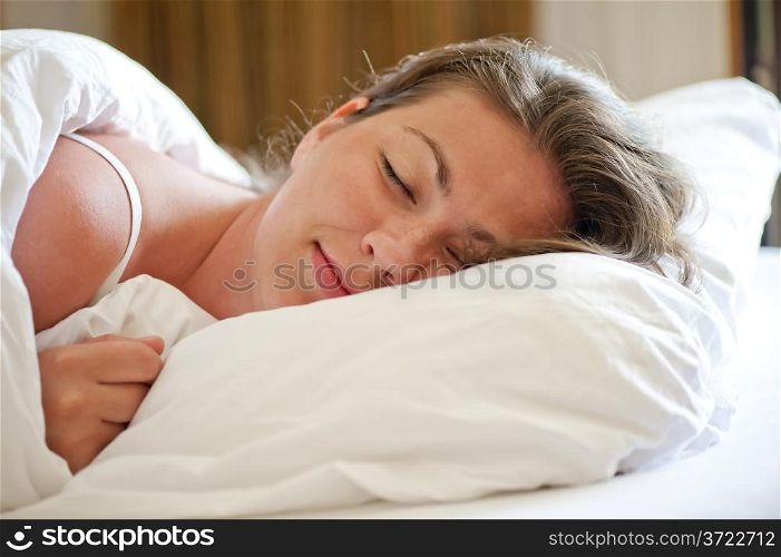woman sleeps on a snow-white bed in the morning