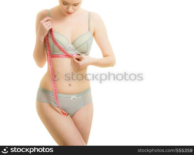 Woman slim girl in bra lingerie with red measure tape measuring her chest breasts. Female body in underwear isolated on white. Woman in bra lingerie measuring her chest breasts.