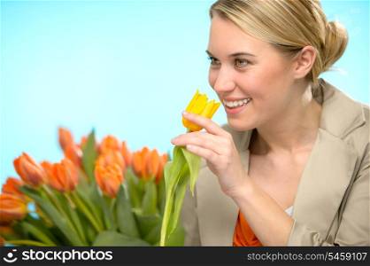 Woman smelling one yellow tulip spring flowers smiling