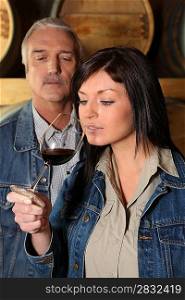Woman smelling wine glass near senior man