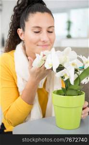 woman smells the flowers at home