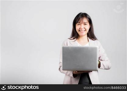 Woman smiling confident smiling holding using laptop computer and typing keyboard for online sending email or chat, Portrait excited happy Asian young female studio shot isolated on white background