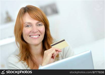woman smiling holding a credit card