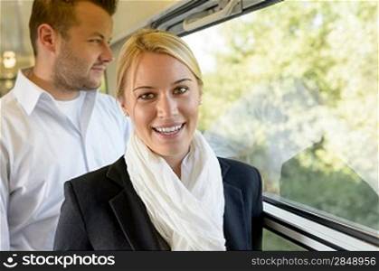 Woman smiling in train man selective focus travel commuters positivity