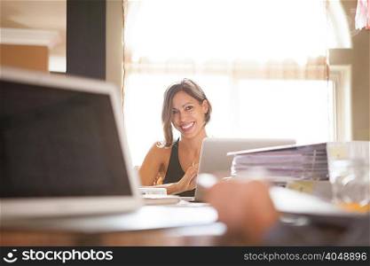 Woman smiling over her work at home