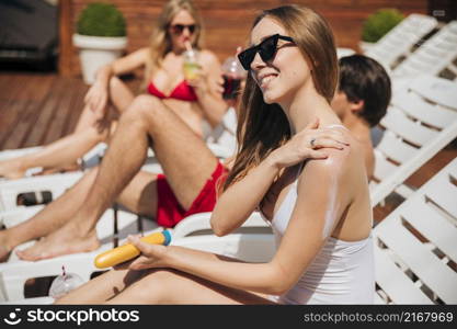 woman smiling putting sunscreen her arm