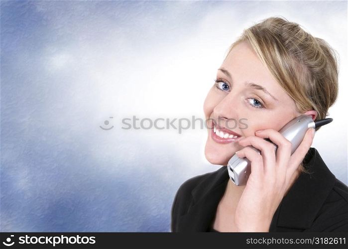 Woman smiling, talking on cordless home phone.