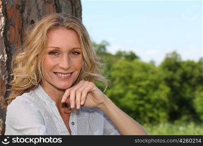 Woman smiling under tree