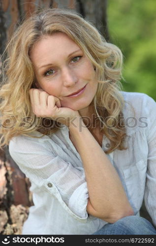 Woman smiling under tree