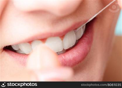 Woman smiling with dental floss.. Oral hygiene and health care. Smiling women use dental floss white healthy teeth.