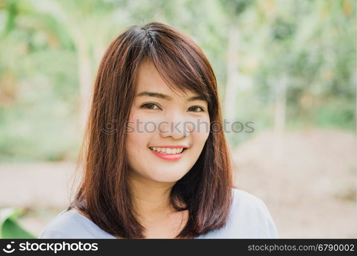 Woman smiling with perfect smile and white teeth in a park and looking at camera