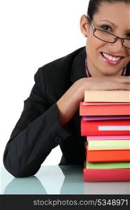 Woman smiling with stack of books