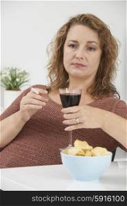 Woman Smoking Cigarette Whilst Drinking Wine And Eating Snacks