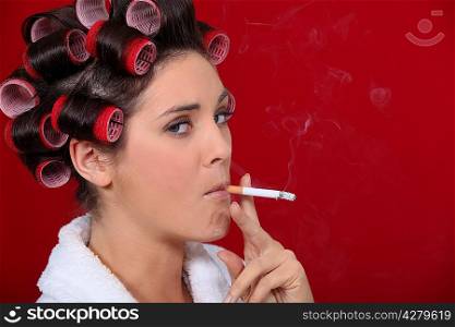 Woman smoking with her hair in rollers