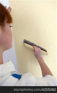 Woman smoothing down wallpaper