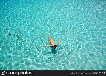 Woman snorkeling in crystal clear turquoise water at tropical beach