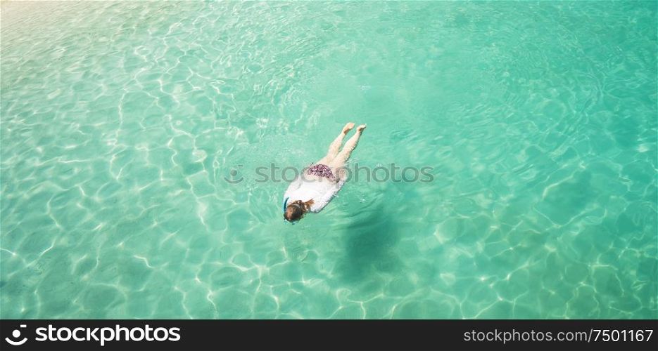 Woman snorkling and relaxing crystal clear and turquoise sea water of the tropical sea .