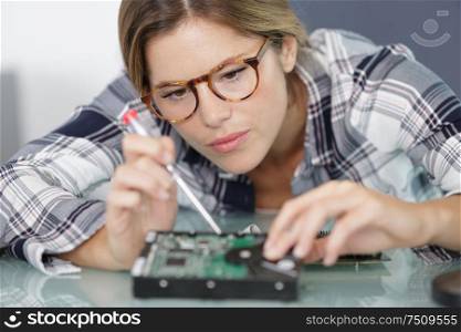 woman soldering elements of circuit board