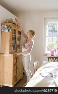 Woman sorting bowls on cupboard top