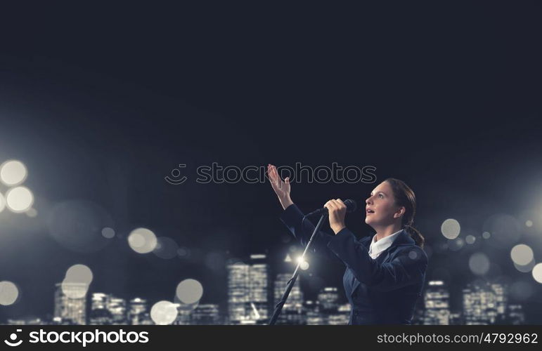 Woman speaker. Woman reporter with microphone gesturing with hand