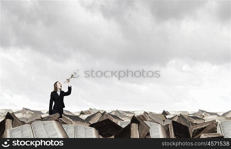 Woman speaking in horn. Young businesswoman in suit proclaiming something in horn
