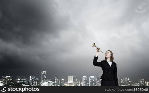 Woman speaking in horn. Young businesswoman in suit proclaiming something in horn