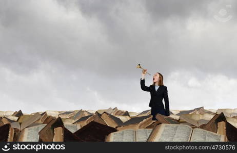 Woman speaking in horn. Young businesswoman in suit proclaiming something in horn