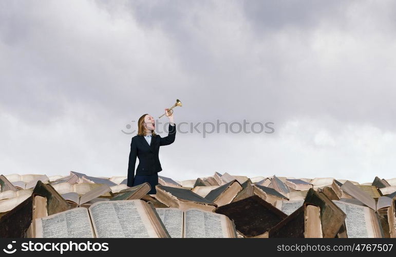 Woman speaking in horn. Young businesswoman in suit proclaiming something in horn