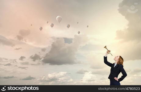 Woman speaking in horn. Young businesswoman in suit proclaiming something in horn