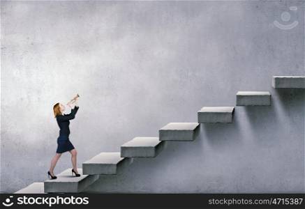 Woman speaking in horn. Young businesswoman on staircase proclaiming something in horn
