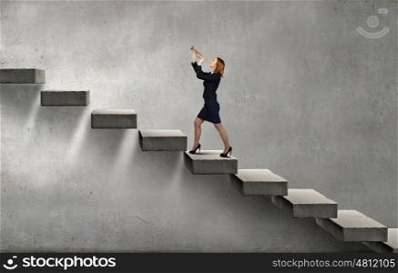 Woman speaking in horn. Young businesswoman on staircase proclaiming something in horn