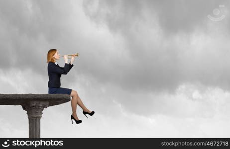 Woman speaking in horn. Young businesswoman sitting on top and proclaiming something in horn