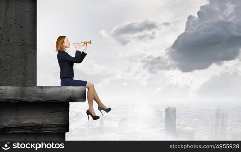 Woman speaking in horn. Young businesswoman sitting on top and proclaiming something in horn